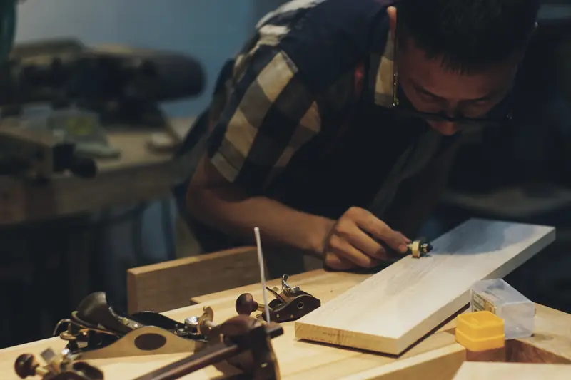 Carpenter working on a piece of wood with hand tools